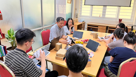 Discussion session with students/participants sitting around a table top that has low-cost air quality sensors