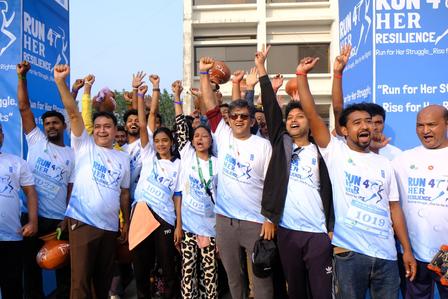 Diverse group in light blue shirts raising fists at a rally outside a building.