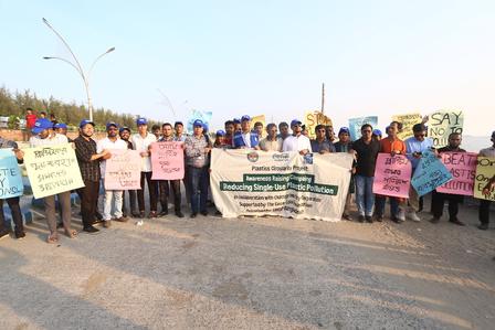 Group of people outdoors holding banners and signs at a demonstration.
