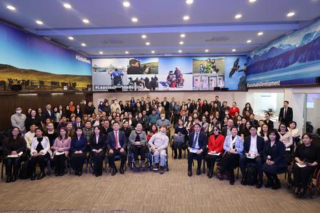 Group photo of a large, diverse crowd in a conference hall.