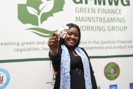 Woman in black outfit with blue scarf showing the taxonomy QR Code card