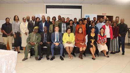 Large group of professionals posing for a group photo in a conference room.