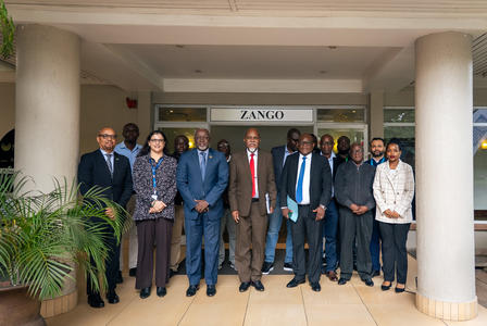 Diverse group of professionals in suits posing outside a columned building.