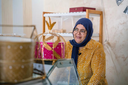 Nabiha dernière le comptoir de sa patisserie 