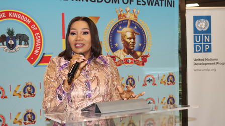 Speaker at a glass podium with Eswatini banners and UNDP logo in the background.
