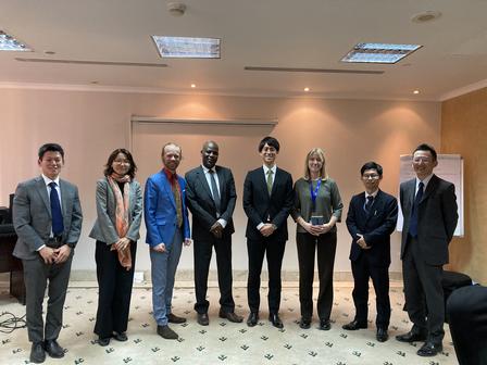 Professionals in business attire pose in a line at a formal awards event.