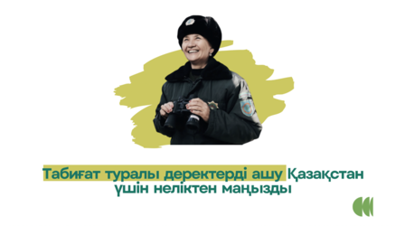 Photograph of a man speaking, with Kazakh text banner and a green logo on the right.