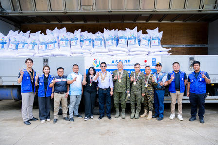 Group photo of people standing in a line in front of a bottled water banner.