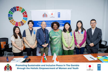 Diverse group of professionals posing for a photo in a conference room with banners and a color wheel backdrop.