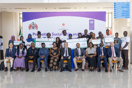 Photograph of diverse professionals posing for a conference group photo in front of a purple banner.