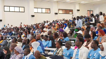 Une salle comble, remplie de participants à une conférence.