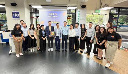 Group of professionals posing for a photo in a modern showroom with displays behind them.