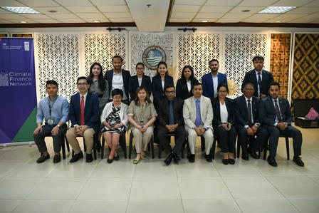 Group of professionals in business attire posing for a formal indoor group photo.