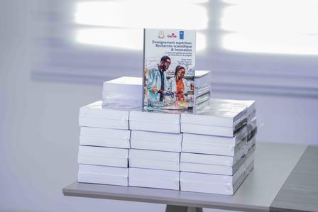 Stack of brochures on a display table; top cover shows a family at the beach.
