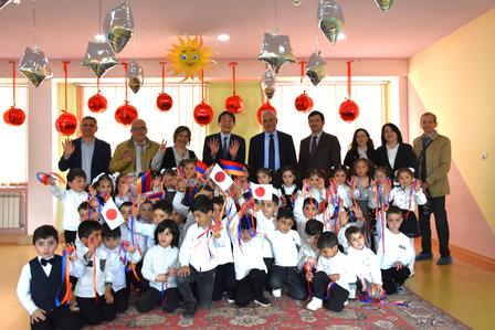 Group of students and teachers posing for a classroom photo with festive decorations.