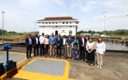 Un grupo de personas paradas frente un edificio del Canal de Panamá