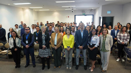 Large diverse group standing in a conference room for a group photo.