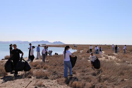 Photograph of a film crew filming in a dry desert landscape with distant mountains.