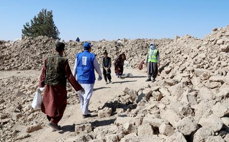 Photograph of a group of people walking through a rocky quarry under a clear blue sky.