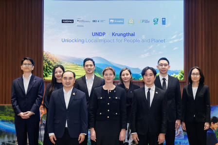 Group of professionals on stage at a UNDP Kunshan event, formal attire, banner in background.