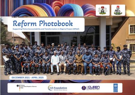 Group photo of students and staff in blue uniforms outside a school, with Reform Photobook banner.