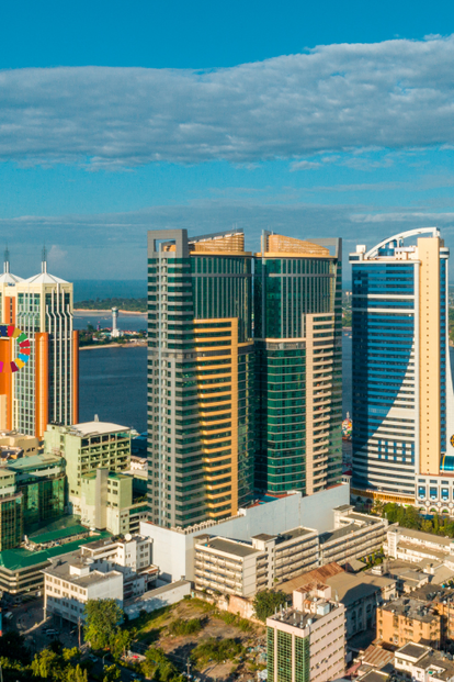 Blue sky over modern glass skyscrapers along the waterfront.