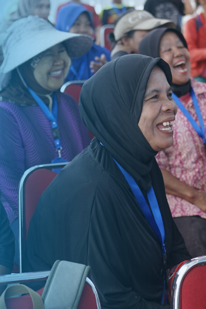 Audience of diverse women wearing hijabs, seated in rows at a conference.