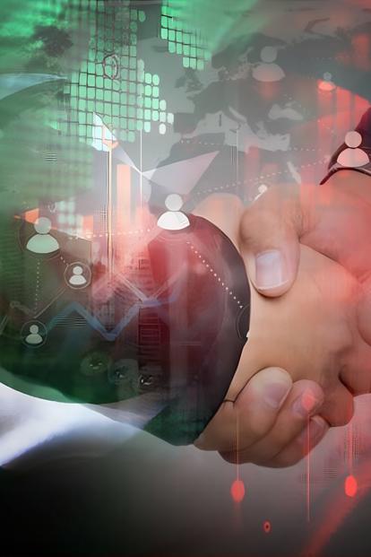 Two hands clasped in a handshake with a glowing globe and digital background in green and red hues.