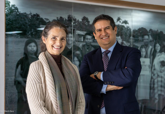 a man and a woman standing in front of a photo