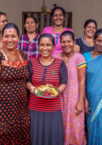 group of women with a plate of food with smiles