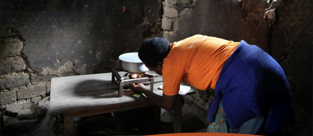 Policy Brief cover with logos; person in orange bends over a kitchen counter in a stone room.