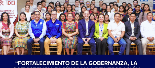 Group of diverse attendees posing for a conference photo under a blue banner.