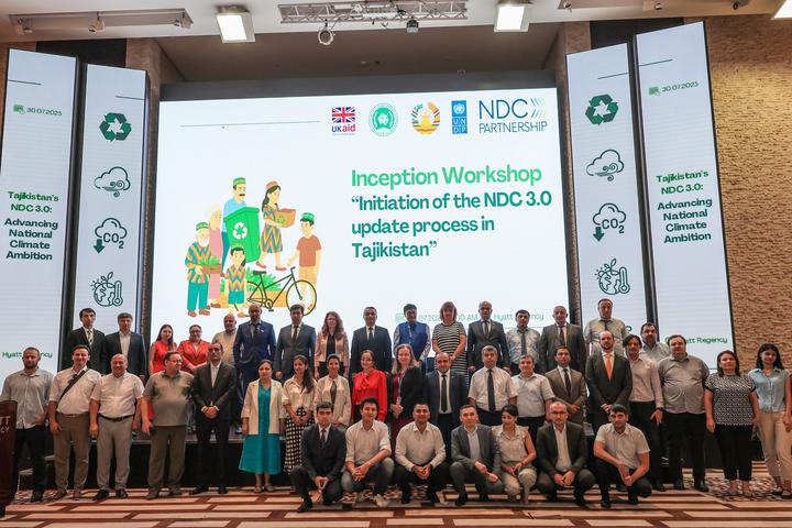 Group photo of workshop participants in front of a large presentation screen.