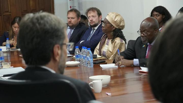 Photograph of diverse professionals seated around a long conference table.